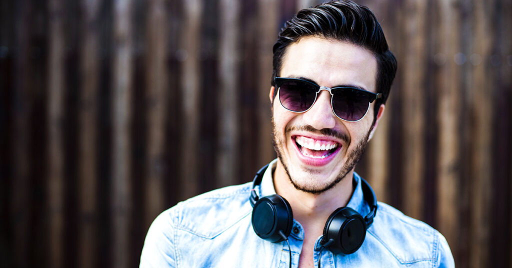 Smiling young man spots a full head of hair