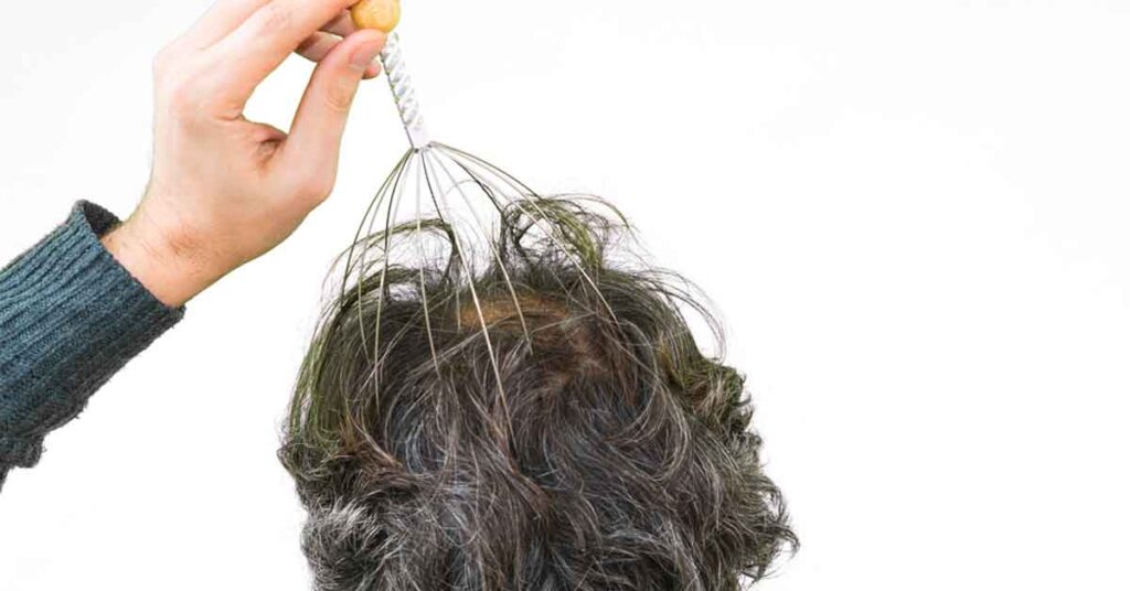 man giving himself a scalp massage
